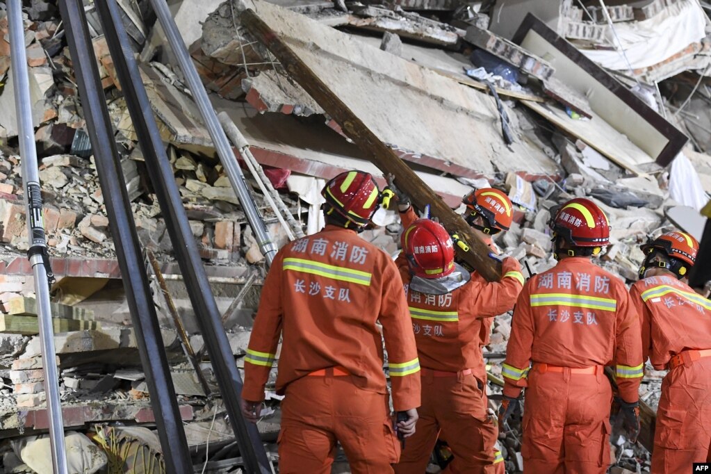 这张照片拍摄于2022年4月29日，显示救援人员在中国湖南省长沙市一栋倒塌的六层建筑中搜寻幸存者。(photo:VOA)