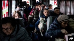 People sit in a bus during evacuation from Lyman, Donetsk region, eastern Ukraine, April 30, 2022.