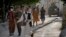 People leave the site of an explosion at a mosque as a Taliban fighter stands guard, in Kabul, Afghanistan, April 29, 2022. A second mosque was targeted in Kabul on Saturday.