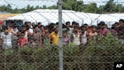 FILE - Displaced Rohingya are seen in a fenced-in camp during a government-organized media tour to a no-man's land between Myanmar and Bangladesh, near Taungpyolatyar village, Maung Daw, northern Rakhine State, Myanmar, June 29, 2018.