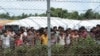 FILE - Displaced Rohingya are seen in a fenced-in camp during a government-organized media tour to a no-man's land between Myanmar and Bangladesh, near Taungpyolatyar village, Maung Daw, northern Rakhine State, Myanmar, June 29, 2018.
