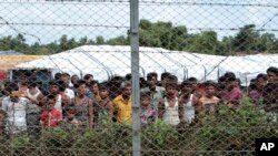 FILE - Displaced Rohingya are seen in a fenced-in camp during a government-organized media tour to a no-man's land between Myanmar and Bangladesh, near Taungpyolatyar village, Maung Daw, northern Rakhine State, Myanmar, June 29, 2018.