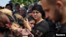 Warga menghadiri pemakaman prajurit Ukraina Volodymyr Kochetov, 46, yang baru-baru ini tewas dalam pertempuran melawan pasukan Rusia di desa Babyntsi, Ukraina, 30 Juni 2022. (Foto: Reuters/Gleb Garanich)