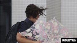 A woman makes her way in strong winds brought by Typhoon Hinnamnor in Naha, Okinawa prefecture, Japan, in this photo taken by Kyodo on September 4, 2022. 