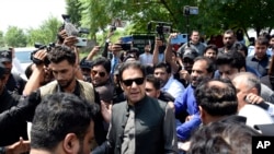 FILE - Former Pakistani Prime Minister Imran Khan, center, arrives to an anti-terrorism court in Islamabad, Pakistan, Sept. 1, 2022.
