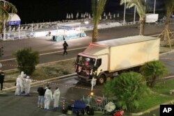 FILE - Authorities investigate a truck after it plowed through Bastille Day revelers in the French resort city of Nice, France, July 14, 2016.