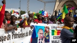 FILE: Malians demonstrate against France and in support of Russia on the 60th anniversary of the independence of the Republic of Mali in 1960, in Bamako, Mali, Sept. 22, 2020. The banner in French reads: "Putin, the road to the future".