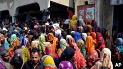 Victims of the unprecedented flooding from monsoon rains wait for relief aid, in Jaffarabad, a district of Pakistan's southwestern Baluchistan province, Sept. 4, 2022.