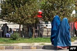 Perempuan Afghanistan berpakaian burqa berjalan melewati kedutaan Rusia setelah serangan bunuh diri di Kabul, 5 September 2022. (Wakil KOHSAR/AFP)