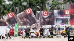 Firefighters and medical personnel carry dummy victims on stretchers during a drill in New Taipei City, Taiwan on July 14, 2022.