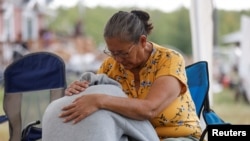 Annie Sanderson comforts her granddaughter, who was close with Gloria Lydia Burns, 62, who was killed on James Smith Cree Nation after a stabbing spree killed 10 people on the reserve and nearby town of Weldon, Saskatchewan, Canada, Sept. 5, 2022. 