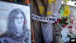Warga Palestina mendirikan monumen peringatan di mana wartawan Al Jazeera Shireen Abu Akleh tewas ditembak oleh tentara Israel, 19 Mei 2022. 