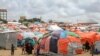 Somali children who fled drought-stricken areas stand by their makeshift shelters at a camp for the displaced on the outskirts of Mogadishu, Sept. 3, 2022. 