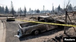 Crime scene tape barricades the area near burned cars, in the aftermath of the Mill Fire, in Weed, California, U.S., Sept. 3, 2022. 