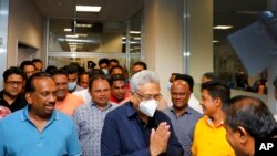 Mantan Presiden Sri Lanka Gotabaya Rajapaksa, mengenakan masker, disambut setibanya di Bandara Internasional Bandaranaike di Colombo, Sri Lanka. (Foto: via AP)