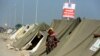 یک زن سیل‌زده کنار چادرهای سازمان‌های امداد در پاکستان - ۴ سپتامبر ۲۰۲۲ 