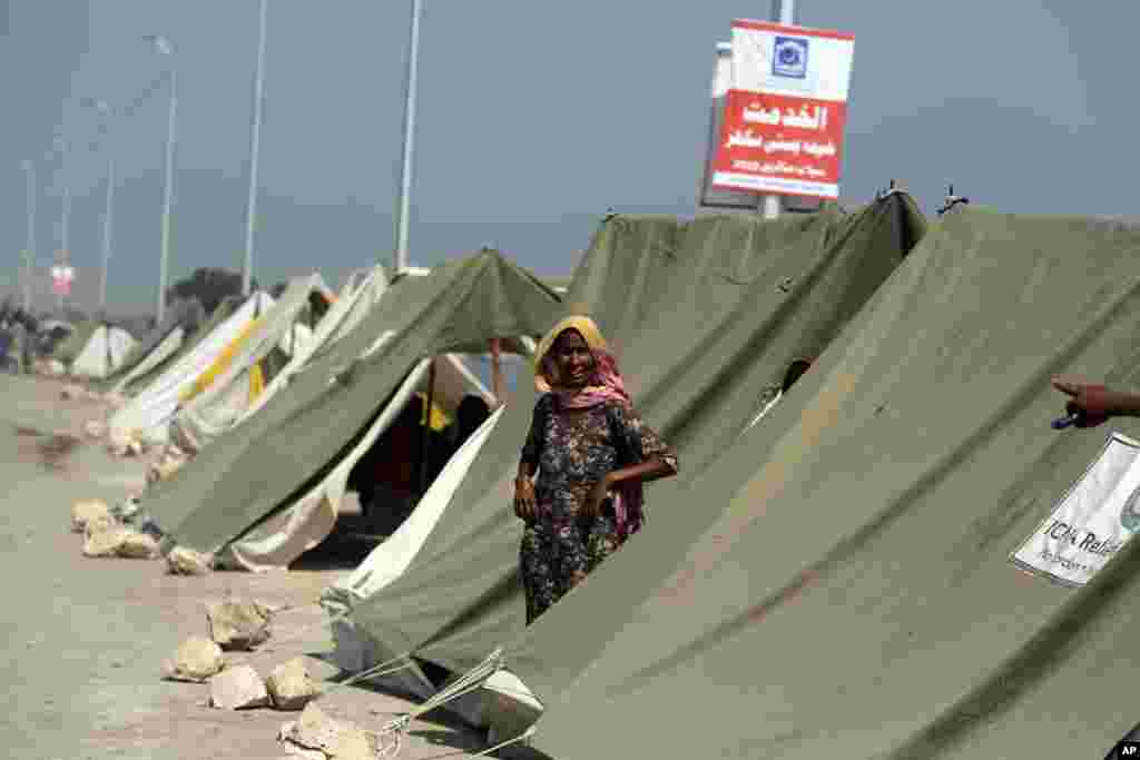 An affected woman takes refuge in a tent area after her home was hit by floods in Sukkur, Pakistan, Sept. 4, 2022. 