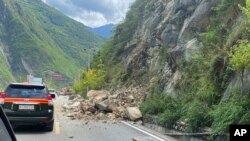 Bebatuan yang berjatuhan terlihat di jalan menuju Kabupaten Luding, pusat gempa di Sichuan, China barat daya, Senin, 5 September 2022, sebagai ilustrasi. Gempa berkekuatan 6,1 SR mengguncang Xinjiang di bagian barat laut China(Foto: Xinhua via AP)