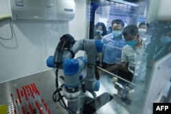 北京举行的2022世界机器人大会展示一个可以做新冠核酸检测的机器人。（2022年8月18日）