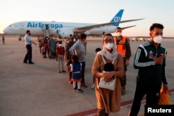 Nilofar Bayat, su marido, y un grupo de refugiados afganos llegan a la base de Torrejón de Ardoz, en Madrid, el 20 de julio de 2021.