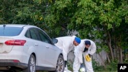 Investigators examine the ground at the scene of a stabbing in Weldon, Saskatchewan on Sept. 4, 2022. A series of stabbings at an Indigenous community and at another in the village of Weldon left multiple people dead and others wounded, Canadian p