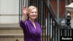 Liz Truss gestures outside the Conservative Party headquarters, after being announced as Britain's next Prime Minister, in London, Sept. 5, 2022. 