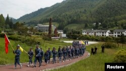 Participants dressed in replica Red Army uniforms march during a Communist team-building course extolling the spirit of the Long March, organized by the Revolutionary Tradition College, in the mountains outside Jinggangshan, Jiangxi province, China, Sept. 14, 2017.