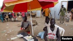 FILE - A money changer waits to do business at his open-air stall at a market in Juba, South Sudan, April 9, 2007. 