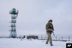 FILE - A Ukrainian border guard patrols the border with Russia not far from Hoptivka village, Kharkiv region, Ukraine, Feb. 2, 2022.