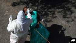 အိန္ဒိယနိုင်ငံ Hyderabad မြို့မှာ အမျိုးသမီးတဦးကို ကိုဗစ်စစ်ဆေးဖို့ Swab နမူနာယူနေတဲ့ ကျန်းမာရေးဝန်ထမ်း။ (ဖေဖော်ဝါရီ ၄၊ ၂၀၂၂)
