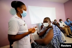 FILE - Medical officer Dr. Emmanuel Addipa-Adapoe, 42, receives a COVID-19 vaccine during the vaccination campaign at the Ridge Hospital in Accra, Ghana, March 2, 2021.