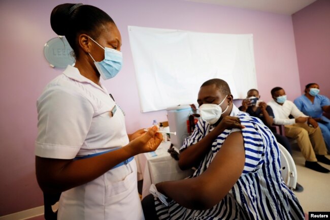 FILE - Medical officer Dr. Emmanuel Addipa-Adapoe, 42, receives a COVID-19 vaccine during the vaccination campaign at the Ridge Hospital in Accra, Ghana, March 2, 2021.