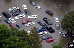 ARCHIVO - Esta fotografía del martes 29 de agosto de 2017 muestra autos inundados cerca del embalse Addicks a medida que aumentan las aguas de Harvey en Houston.