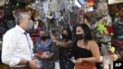 Otto Guevara, candidato a la Asamblea Nacional por el Partido Unión Liberal, hace campaña en un mercado, el jueves 3 de febrero de 2022, en San José. (AP Foto/Carlos González)