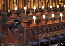 FILE - Britain's Queen Elizabeth II sits alone in St. George's Chapel during the funeral of Prince Philip, at Windsor Castle, Windsor, England, Saturday April 17, 2021. (Jonathan Brady/Pool via AP, File)