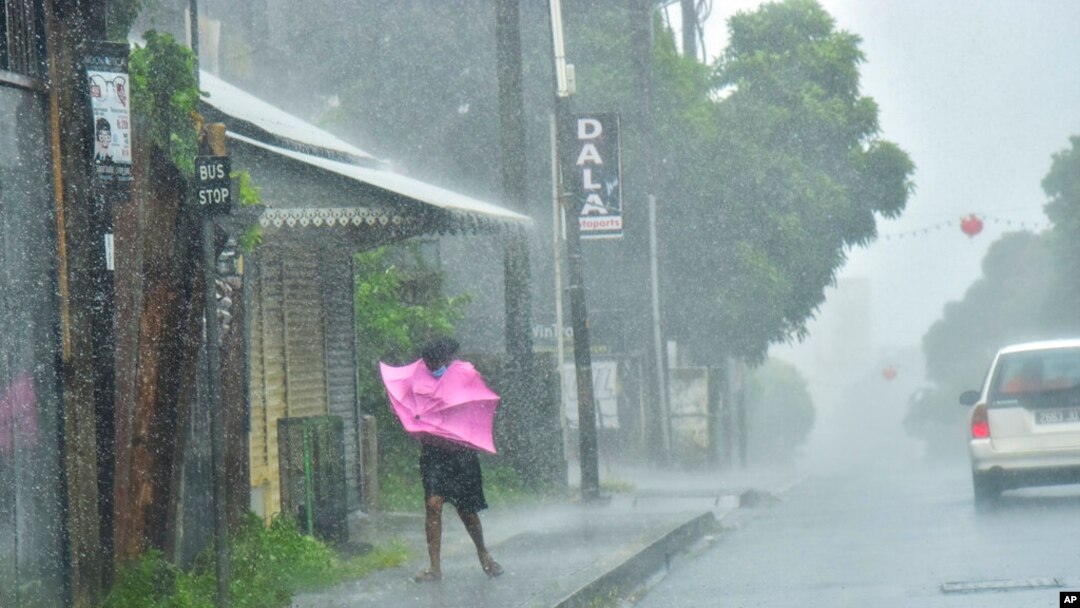 A woman fights gale force winds in the Indian Ocean Island of Mauritius, Feb. 2, 2022. Forecasts say Tropical Cyclone Batsirai is increasing in intensity and is expected to make landfall in central Madagascar on Feb. 5, 2022.
