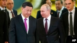 Presiden China Xi Jinping dan Presiden Rusia Vladimir Putin memasuki aula untuk melakukan pembicaraan di Kremlin di Moskow, 5 Juni 2019. (Foto: AP)