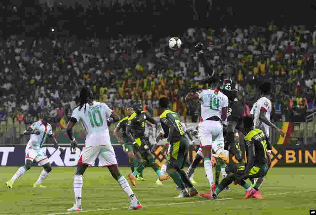 Burkina Faso&#39;s goalkeeper Farid Ouedraogo, top, punches the ball during the semifinal soccer match against Senegal in Cameroon, Feb. 2, 2022.