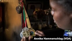 Oumy Dieye, Senegal's only professional female golfer, looks at her medals at her home in Saly, Jan. 25, 2022. (Annika Hammerschlag/VOA)