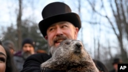 A.J. Dereume kenbe Punxsutawney Phil, yon marmot ki ka predi tan an, pandan 136e selebrasyon Groundhog Day, nan eta Pensilvani, 2 Fevriye 2022. 