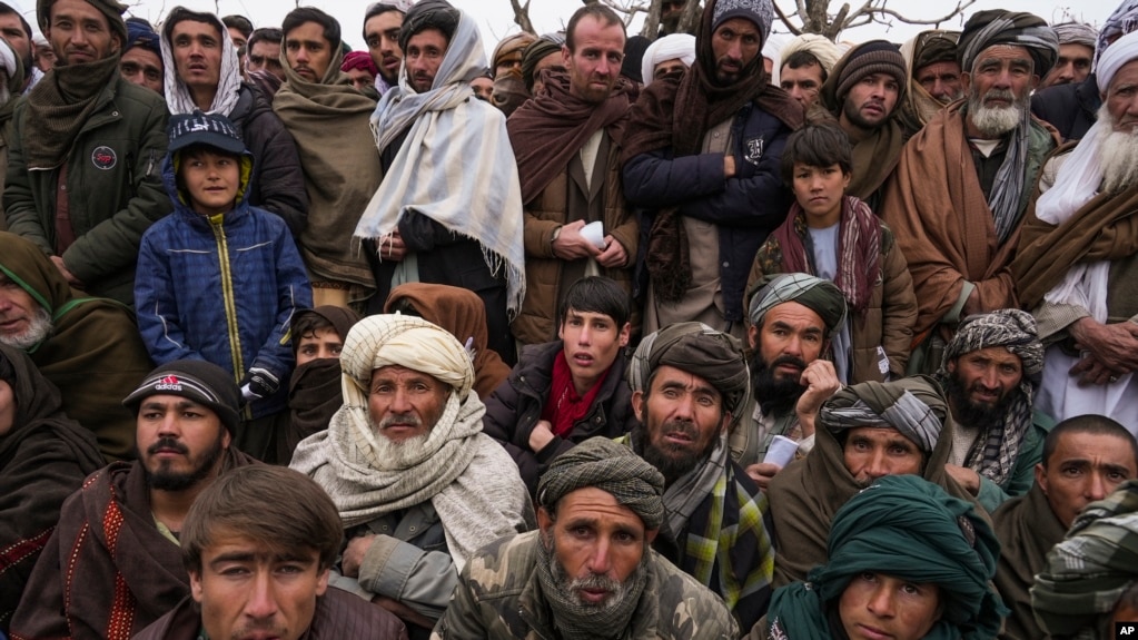 FILE - Hundreds of Afghan men gather to apply for humanitarian aid, in Qala-e-Naw, Afghanistan, Dec. 14, 2021.