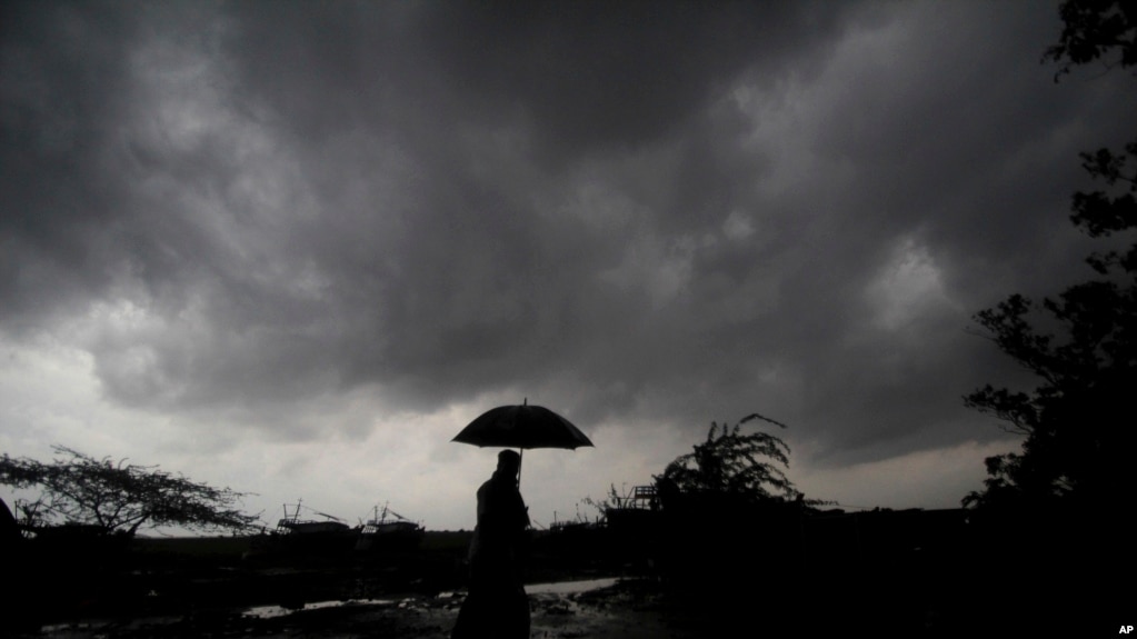 FILE - A villager under dark clouds in Balasore area in Odisha, India on May 25, 2021, ahead of a powerful storm heading toward the eastern coast. (AP Photo/File)