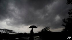 FILE - A villager under dark clouds in Balasore area in Odisha, India on May 25, 2021, ahead of a powerful storm heading toward the eastern coast. (AP Photo/File)