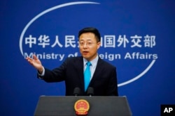 FILE - Chinese Foreign Ministry spokesman Zhao Lijian gestures as he speaks during a daily briefing at his ministry in Beijing, Feb. 24, 2020.