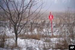 Signs warn of minefields close to the line that separates the areas controlled by the Ukrainian military from those controlled by pro-Russian separatists, in Avdiivka, Donetsk region, eastern Ukraine, Feb. 3, 2022.