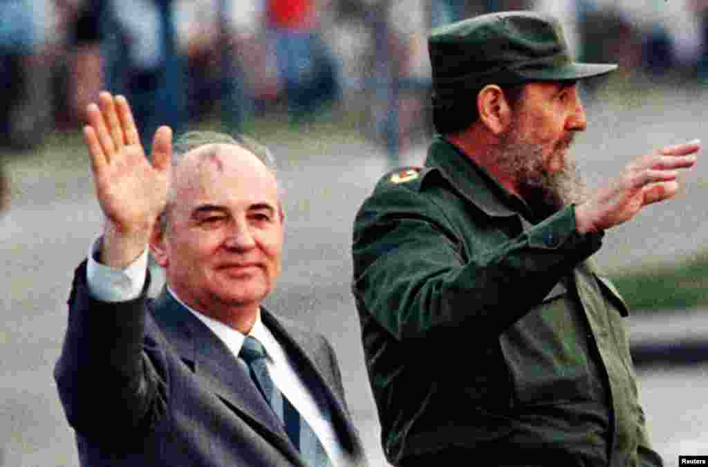 Then Soviet leader Mikhail Gorbachev and then Cuban leader Fidel Castro wave from an open top car as it drives through Havana's Revolution Square, April 2, 1989.