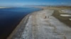 Dos personas caminan el 6 de septiembre de 2022 por la ribera del Gran Lago Salado, en Utah, EEUU, donde el nivel del agua ha descendido a mínimos históricos. 