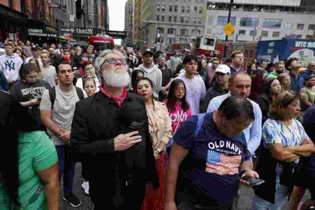 People observe a moment of silence on Cedar Street by the perimeter of the commemoration ceremony of the 9/11 terror attacks, in New York, Sept. 1, 2022.