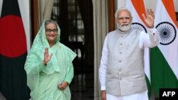 ভারতের প্রধানমন্ত্রী নরেন্দ্র মোদি এবং বাংলাদেশের প্রধানমন্ত্রী শেখ হাসিনা নয়াদিল্লির হায়দ্রাবাদ হাউসে তাদের বৈঠকের আগে ছবির তোলার সময় হাত নাড়ছেন।৬ সেপ্টেম্বর,২০২২। এএফপি ফাইল ছবি।