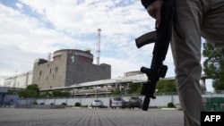 FILE: A security person stands in front of the Zaporizhzhia nuclear power plant, amid the ongoing Russian military action in Ukraine, Sept. 11, 2022. 